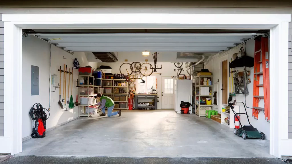 Man inspecting a garage during a garage conversion project, showcasing the transformation into a functional living space