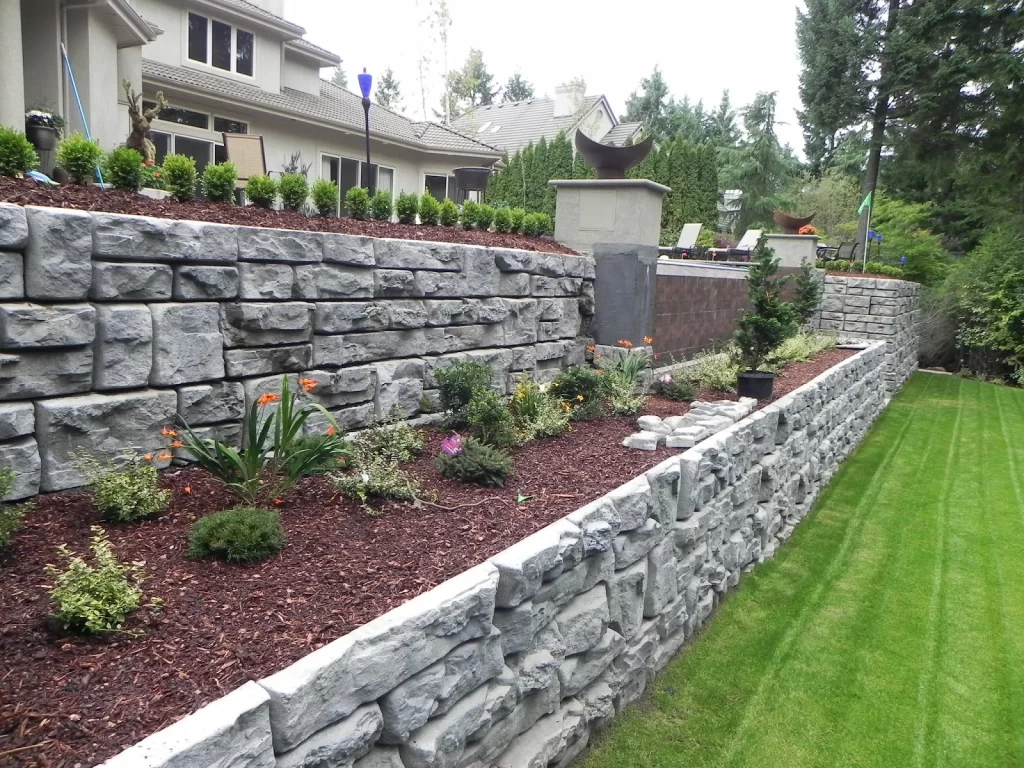 a stone retaining wall in front of a house